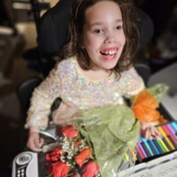 Happy girl smiling after piano performance affected by ECHS1 Deficiency